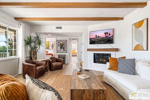 living room with beamed ceiling and light hardwood / wood-style flooring