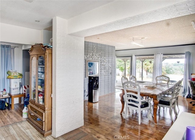 dining space with hardwood / wood-style floors and a textured ceiling