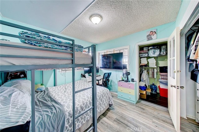 bedroom featuring light wood-type flooring and a textured ceiling