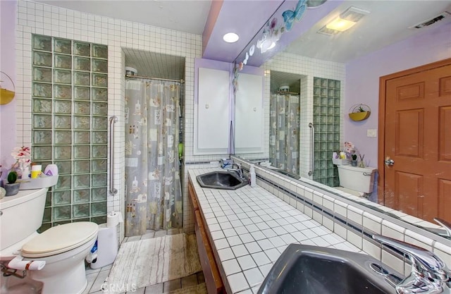 bathroom featuring toilet, sink, and tile walls