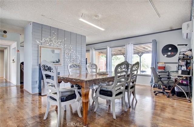 dining area featuring a wall mounted air conditioner, wood-type flooring, and a textured ceiling