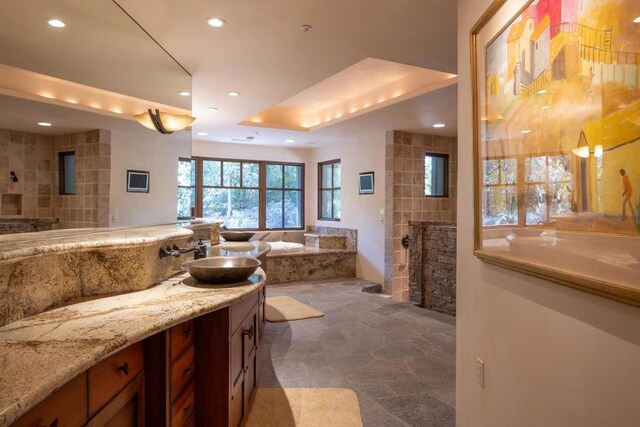 bathroom with a relaxing tiled tub and vanity