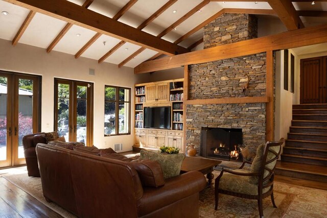 living room featuring a stone fireplace, wood-type flooring, french doors, high vaulted ceiling, and beam ceiling