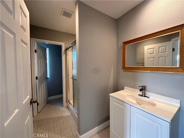 bathroom featuring vanity and a shower with shower door