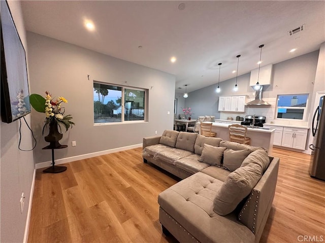 living room with vaulted ceiling and light hardwood / wood-style flooring