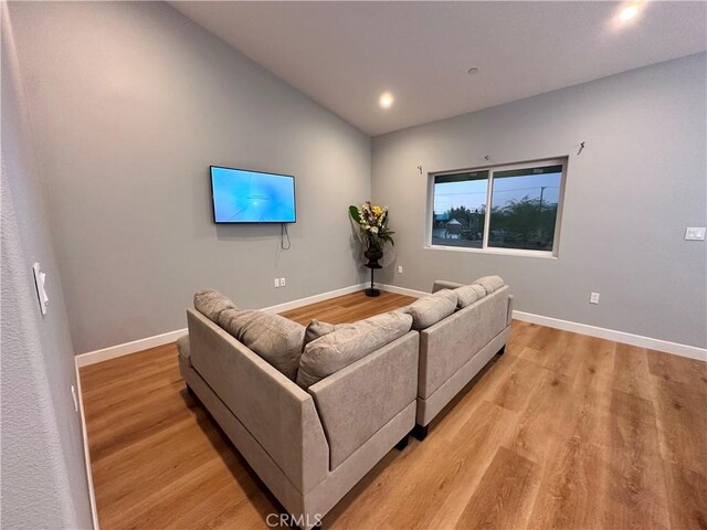 living room with light hardwood / wood-style flooring and lofted ceiling