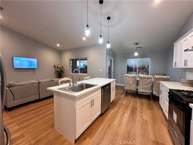 kitchen with sink, gas range oven, stainless steel dishwasher, an island with sink, and white cabinets