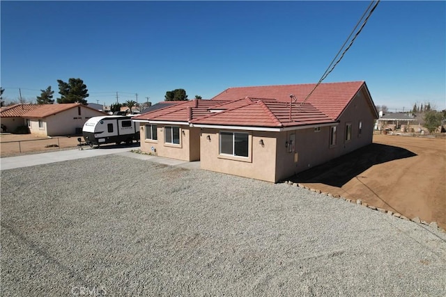 view of front of home featuring stucco siding, driveway, and a tile roof