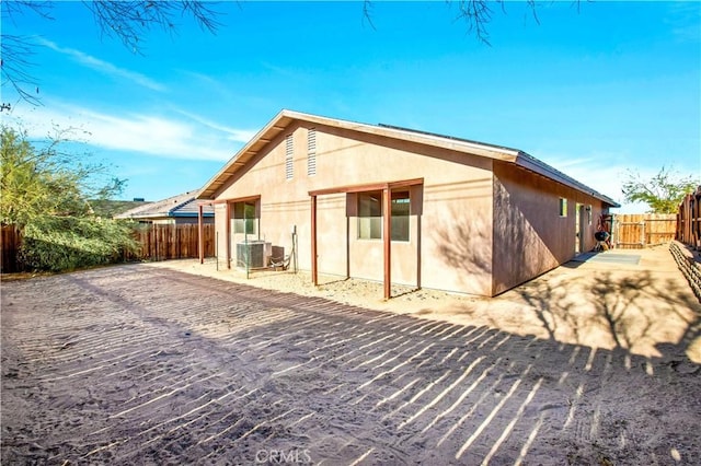 rear view of property featuring central air condition unit and a patio