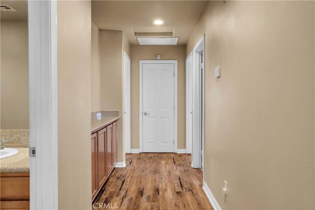 hall featuring light wood-type flooring and sink