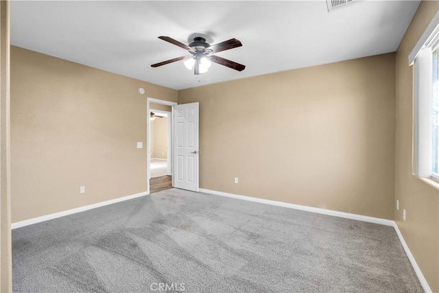 carpeted spare room featuring ceiling fan