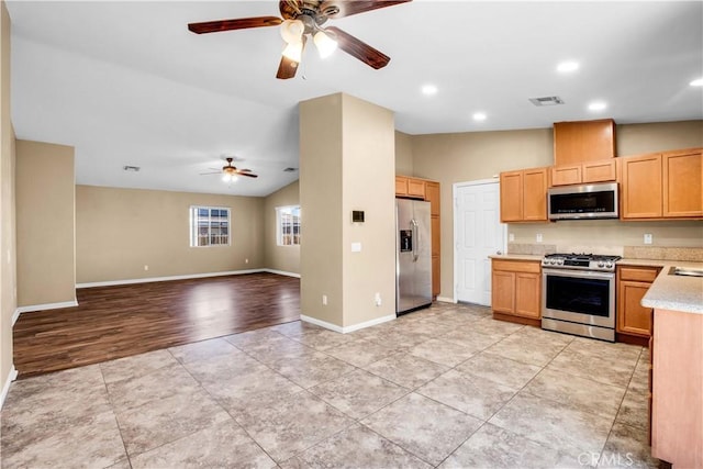 kitchen with ceiling fan, light hardwood / wood-style floors, lofted ceiling, light brown cabinetry, and appliances with stainless steel finishes