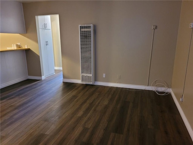 unfurnished room with dark wood-type flooring