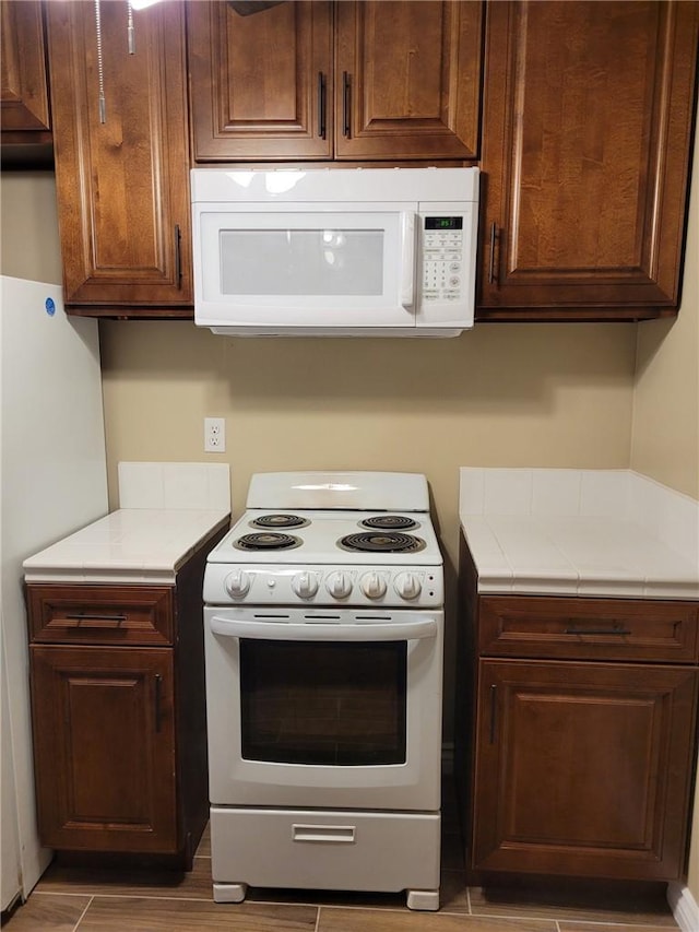 kitchen with dark brown cabinets and white appliances