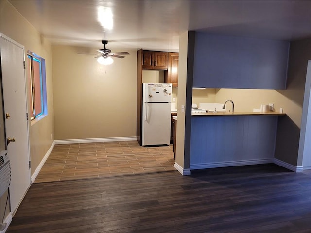 kitchen featuring dark hardwood / wood-style floors, white fridge, sink, and ceiling fan