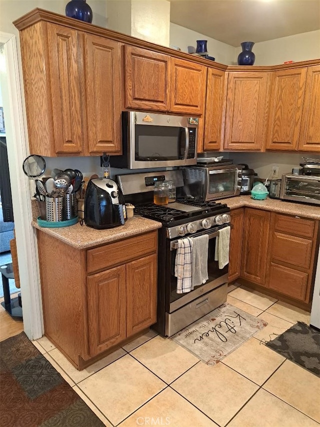 kitchen featuring light tile patterned flooring and stainless steel appliances