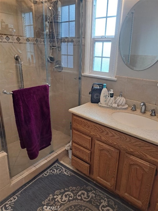 bathroom featuring vanity, walk in shower, and tile patterned flooring