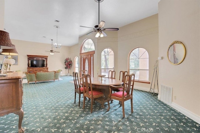 dining area with ceiling fan and dark carpet