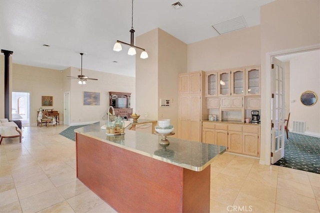 kitchen featuring ceiling fan, light tile patterned floors, and a high ceiling