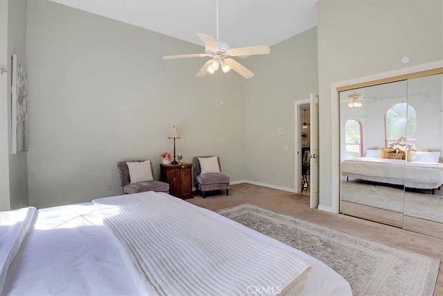 carpeted bedroom featuring ceiling fan, a closet, and high vaulted ceiling