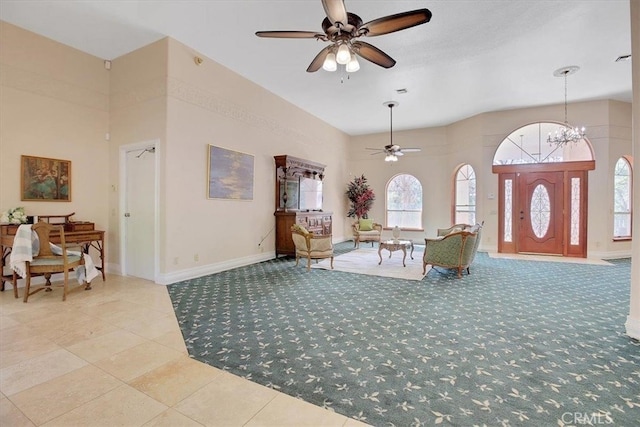 entryway with ceiling fan with notable chandelier and light tile patterned floors