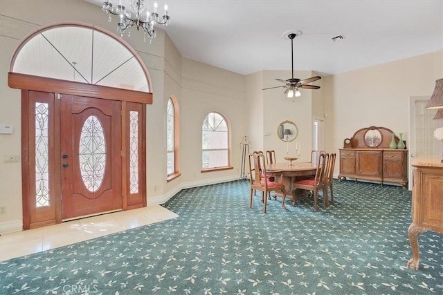 foyer featuring ceiling fan with notable chandelier and carpet flooring