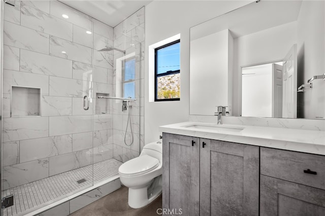 bathroom featuring a shower with door, vanity, and toilet