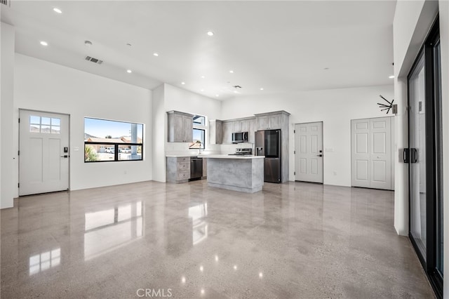 unfurnished living room featuring a high ceiling