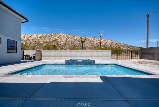 view of swimming pool with an in ground hot tub, a mountain view, and a patio