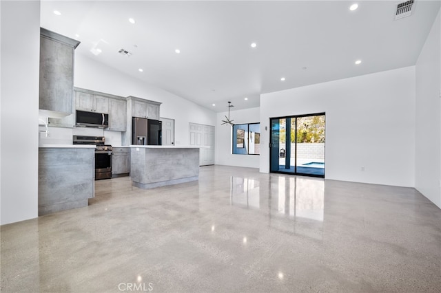 kitchen featuring gray cabinets, stainless steel appliances, vaulted ceiling, and a kitchen island