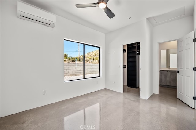 unfurnished bedroom featuring a walk in closet, ensuite bath, a closet, ceiling fan, and a wall mounted AC