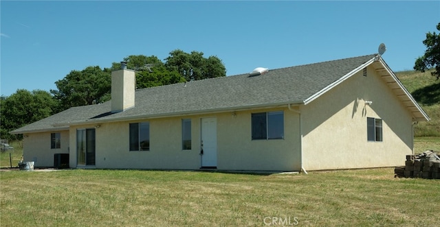 back of property featuring a lawn and central AC unit