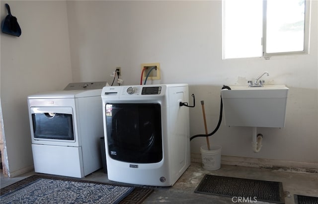 clothes washing area with sink and washer and clothes dryer