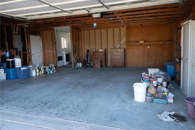 garage featuring electric panel, washer and dryer, and a garage door opener