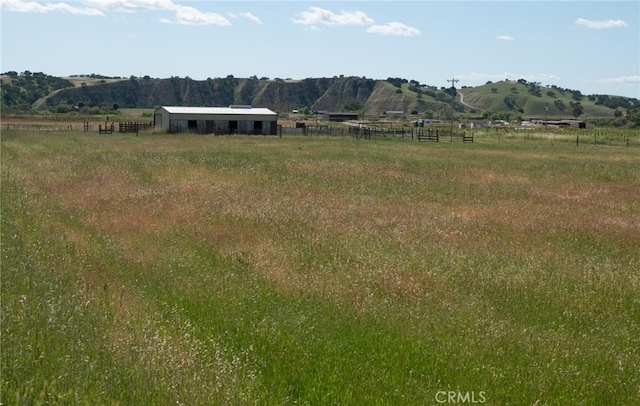 view of yard with a rural view and a mountain view