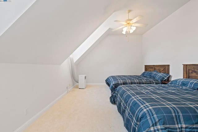 bedroom with ceiling fan, carpet floors, and lofted ceiling with skylight