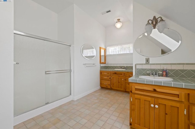 bathroom with tile patterned flooring, decorative backsplash, a shower with shower door, and vanity