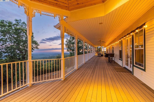 deck at dusk featuring french doors and ceiling fan