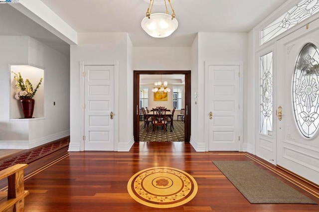 foyer featuring a notable chandelier and dark wood-type flooring