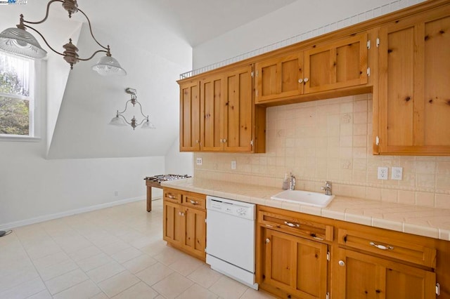 kitchen with decorative light fixtures, white dishwasher, tasteful backsplash, and sink