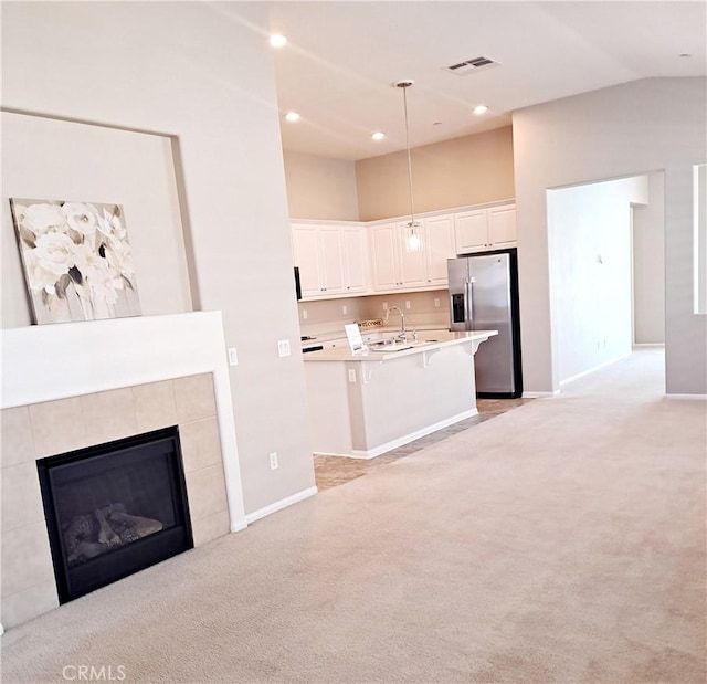 kitchen featuring white cabinets, visible vents, light colored carpet, and stainless steel fridge with ice dispenser