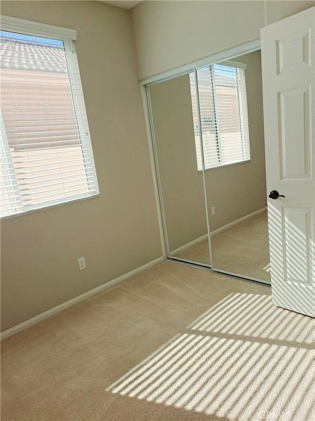 unfurnished bedroom featuring carpet, a closet, and baseboards