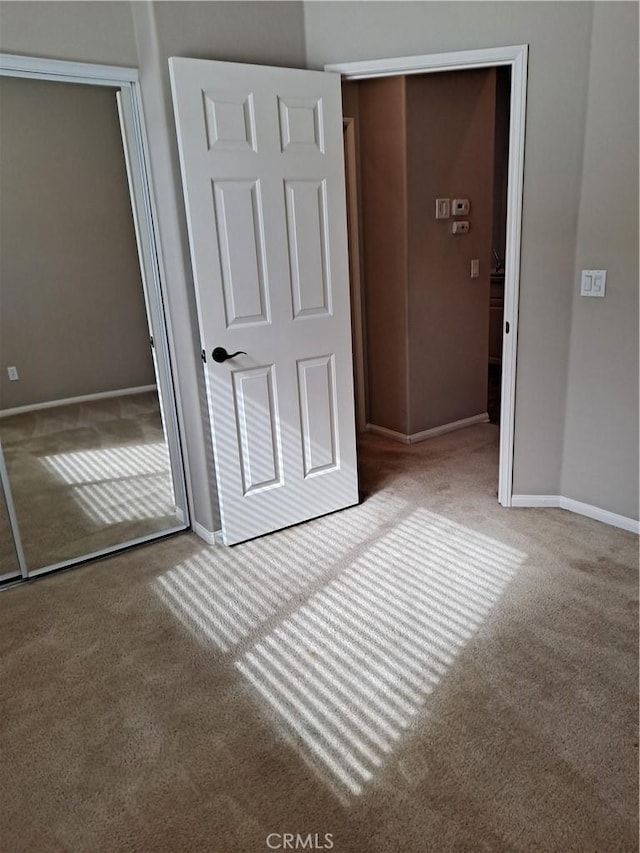 unfurnished bedroom with a closet, carpet flooring, and baseboards