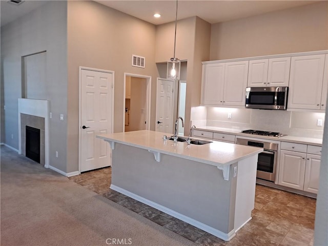 kitchen with appliances with stainless steel finishes, a sink, visible vents, and white cabinets