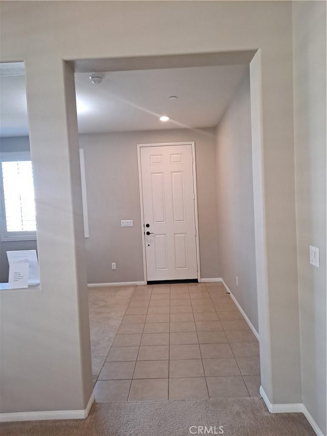 foyer featuring light tile patterned floors and baseboards