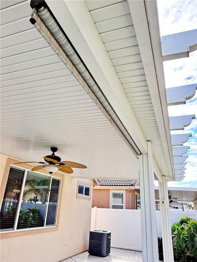 exterior details with fence, cooling unit, a ceiling fan, and stucco siding