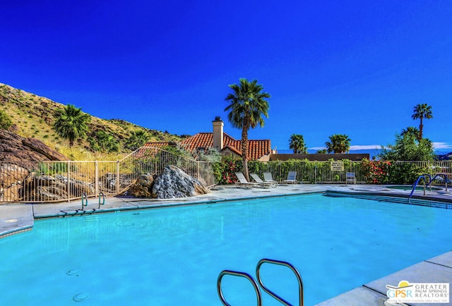 view of swimming pool with a mountain view