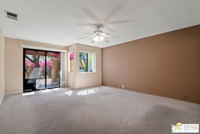 carpeted spare room with plenty of natural light and ceiling fan