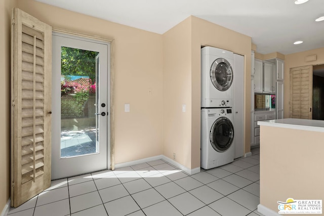 laundry area featuring light tile patterned floors and stacked washer / drying machine