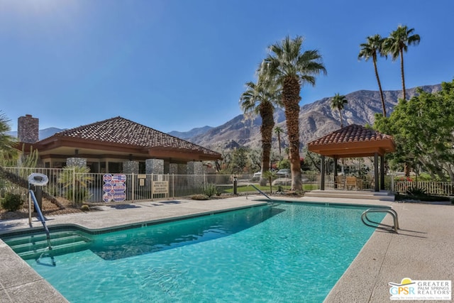 view of swimming pool with a gazebo, a patio area, and a mountain view